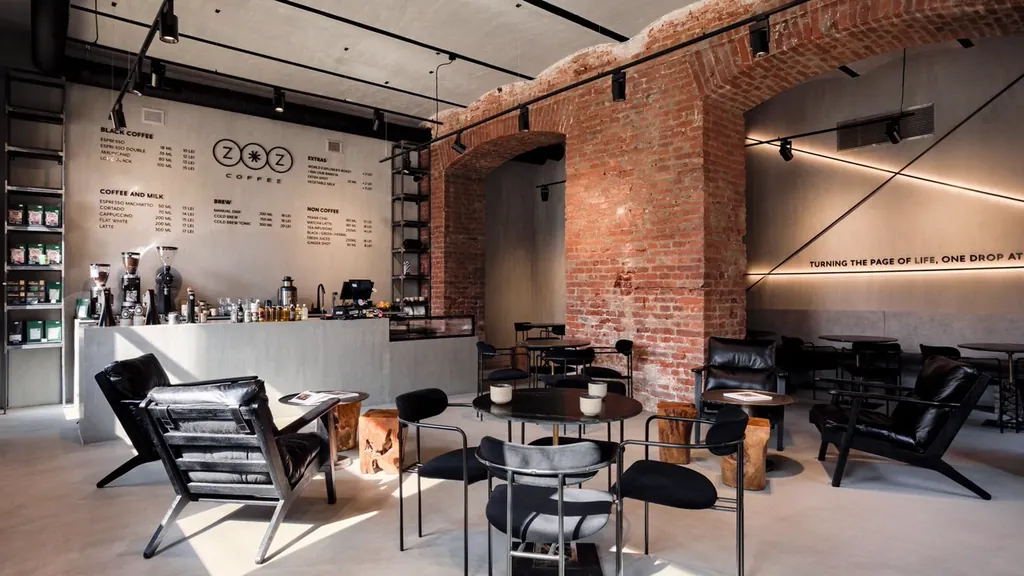 Zoz Coffee, spațiul realizat: arcade de cărămidă la vedere, fotolii negre și spoturi pe șine.
